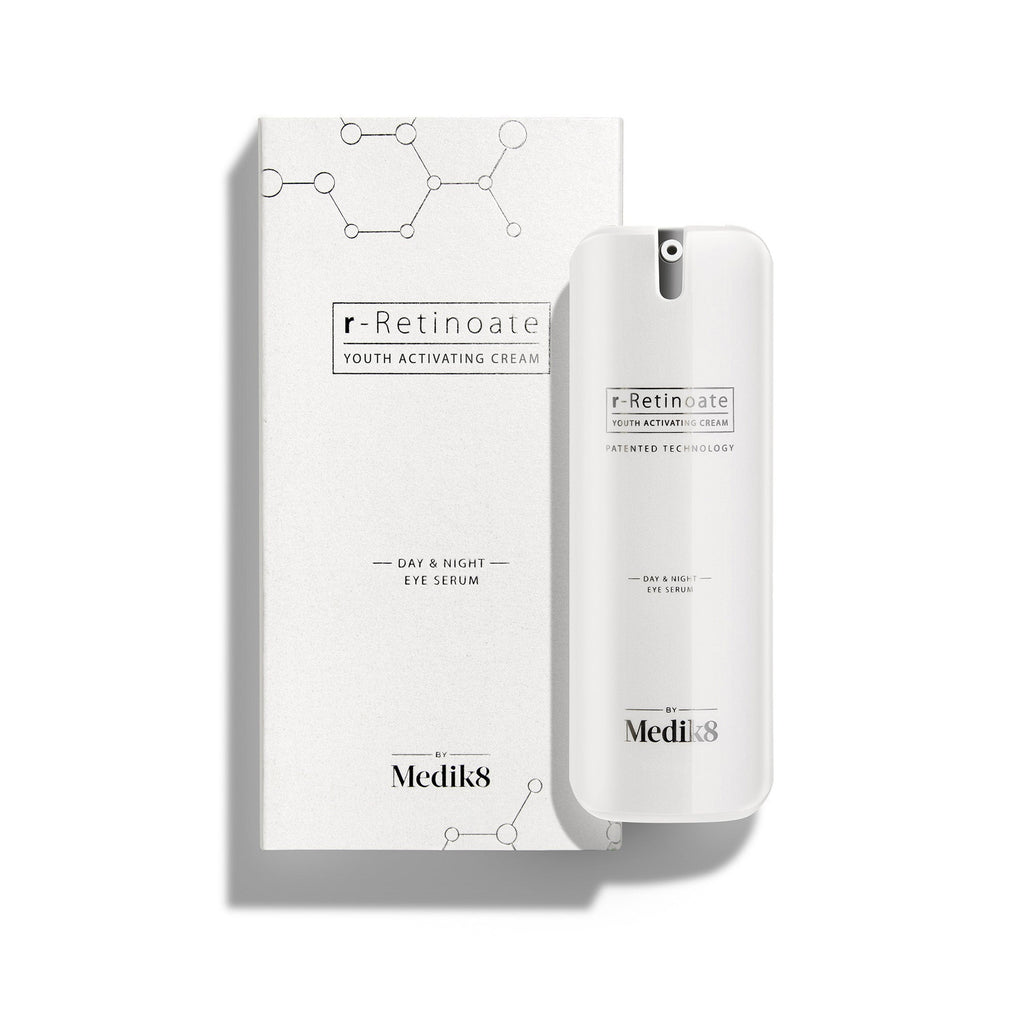 Botella blanca con dispensador de r-Retinoate Day & Night Eye Serum colocada junto a su caja de cartón blanca a juego.
