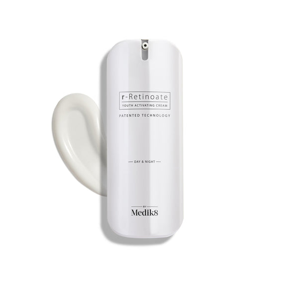 Un elegante frasco blanco con dispensador de r-Retinoate Day & Night se mantiene en posición vertical, con un remolino de crema blanca al lado.-32