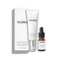Una caja de cartón blanca se encuentra junto a un tubo blanco de Balance Moisturiser y un pequeño frasco de vidrio marrón de Glycolic Acid Activator.