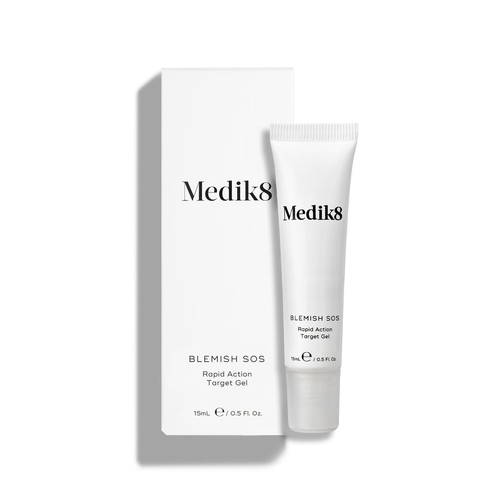 Un tubo blanco de Blemish SOS (15 mL) se encuentra junto a su caja blanca.