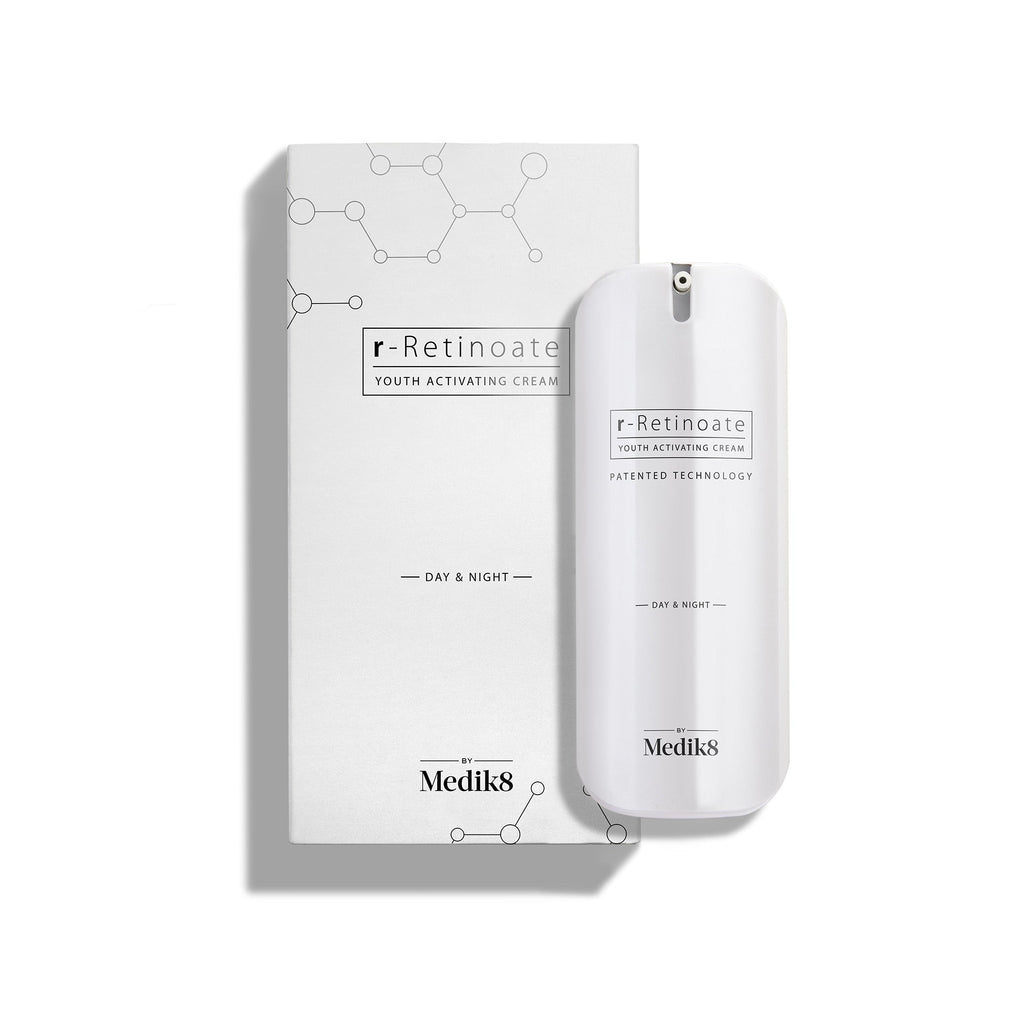 Un elegante frasco blanco con dispensador tipo pump de r-Retinoate Day & Night se muestra junto a su estuche blanco a juego.