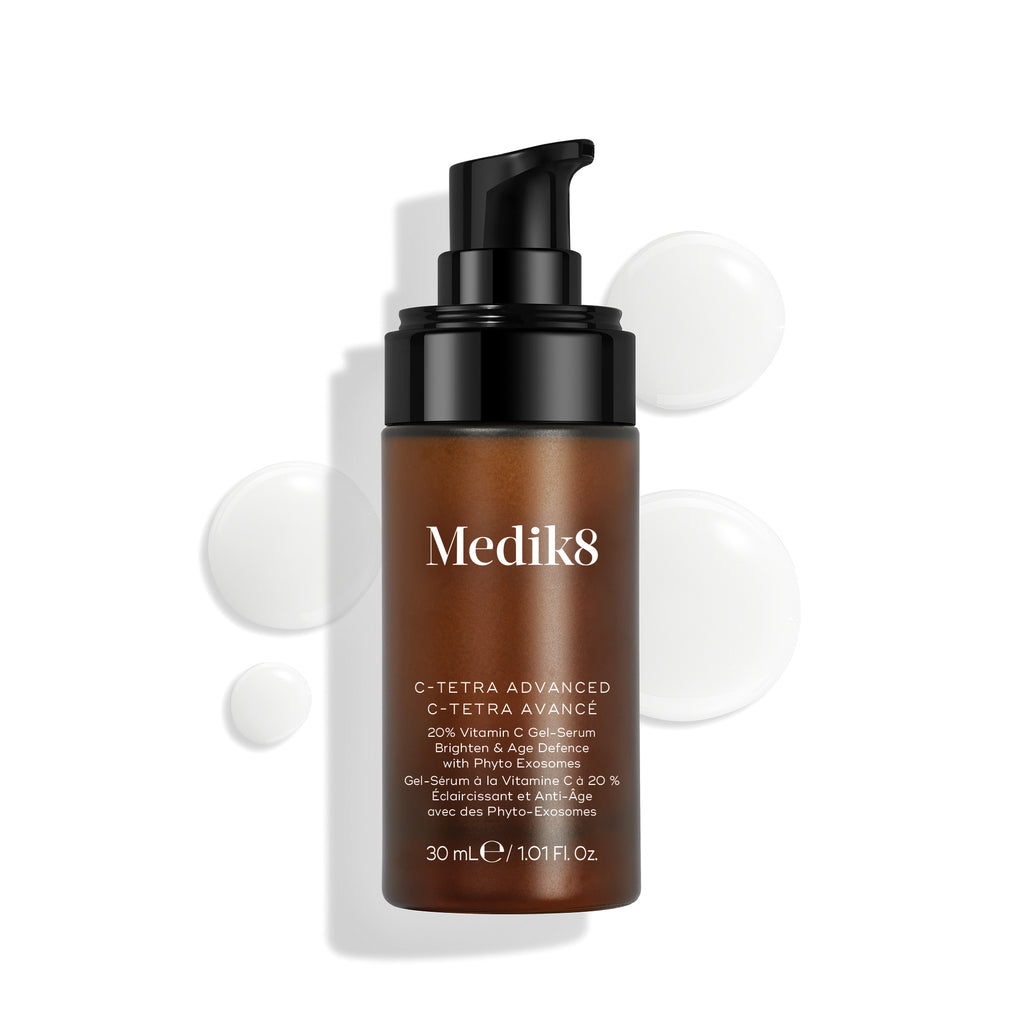Botella de Medik8 C-Tetra Advanced mostrada sobre un fondo blanco limpio con gotas translúcidas de sérum, destacando su textura ligera de gel-sérum.
