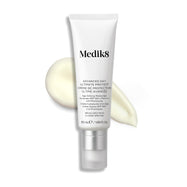Un tubo blanco de Advanced Day Ultimate Protect está colocado en posición vertical, con una muestra de crema ligera junto a él.
