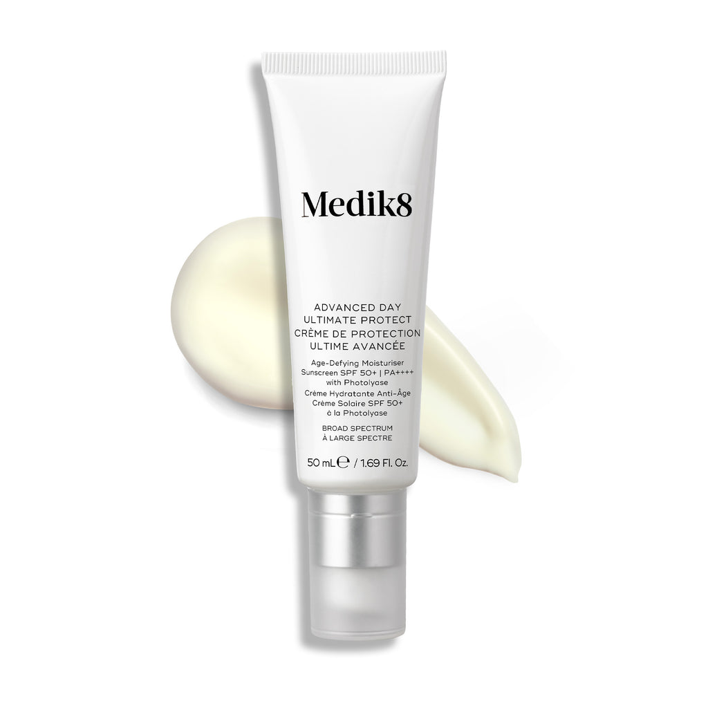 Un tubo blanco de Advanced Day Ultimate Protect está colocado en posición vertical, con una muestra de crema ligera junto a él.

