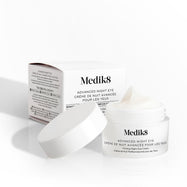 El tarro de Medik8 Advanced Night Eye aparece abierto junto a su caja de empaque sobre un fondo blanco. El texto destaca la fórmula de “Crema Rejuvenecedora para el Contorno de Ojos” y su tamaño de 15 mL.