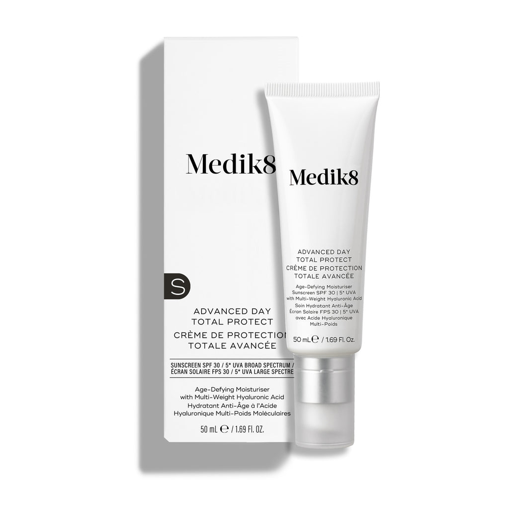 Crema hidratante Medik8 Advanced Day Total Protect SPF 30, presentada en un tubo blando blanco con tapón transparente y su envase de cartón blanco en el lateral