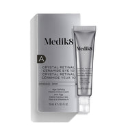La crema para el contorno de ojos «Medik8 Crystal Retinal Ceramide Eye 10», mostrada con su caja de presentación plateada y blanca y un tubo a juego sobre un fondo blanco.