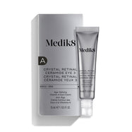 La crema para el contorno de ojos «Medik8 Crystal Retinal Ceramide Eye 3», mostrada con su caja de presentación plateada y blanca y un tubo a juego sobre un fondo blanco.