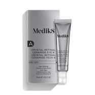 La crema para el contorno de ojos «Medik8 Crystal Retinal Ceramide Eye 6», mostrada con su caja de presentación plateada y blanca y un tubo a juego sobre un fondo blanco.
