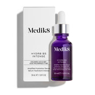 El frasco de vidrio con gotero de Medik8 Hydr8 B5 Intense se encuentra junto a su caja exterior blanca a juego sobre un fondo blanco limpio. El texto en ambos identifica el producto como un suero de ácido hialurónico con NMF de 30 mL diseñado para reponer y potenciar.