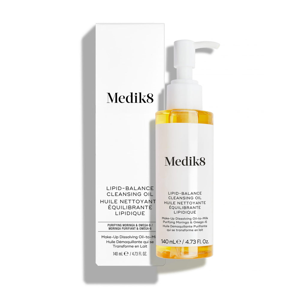 Frasco del aceite limpiador Lipid-Balance de Medik8, con un dosificador de bomba blanco, junto a su caja de embalaje blanca, sobre un fondo blanco impecable con una suave sombra.