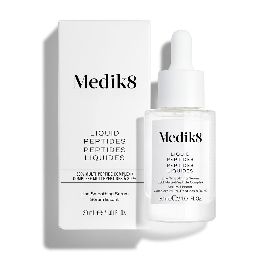 Un frasco cuentagotas de vidrio transparente del sérum Liquid Peptides se encuentra frente a su caja blanca del producto.