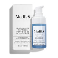 Sérum clarificante y refinador de poros con péptidos de niacinamida de Medik8, mostrado con su caja blanca de venta al público y un frasco con dosificador azul sobre un fondo blanco limpio.