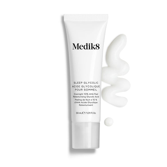Tubo de Medik8 Sleep Glycolic sobre un fondo blanco limpio con una franja ondulada y una pequeña gota de textura de crema blanca. El texto identifica el producto como un «Peeling nocturno con AHA de liberación prolongada para uso en casa» en formato de 30 ml.-35