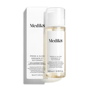 La botella del tónico Medik8 Press & Glow se encuentra frente a su caja blanca de producto a juego sobre un fondo blanco limpio. El texto en ambos identifica el producto como un tónico exfoliante diario con PHA y activador enzimático de 200 mL.
