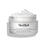 El tarro de crema Advanced Night Restore aparece abierto con una generosa porción de crema blanca en la parte superior, sobre un fondo blanco limpio, destacando su textura suave y reparadora. El texto negro del envase lo describe como “Crema de noche rejuvenecedora con multiceramidas”.