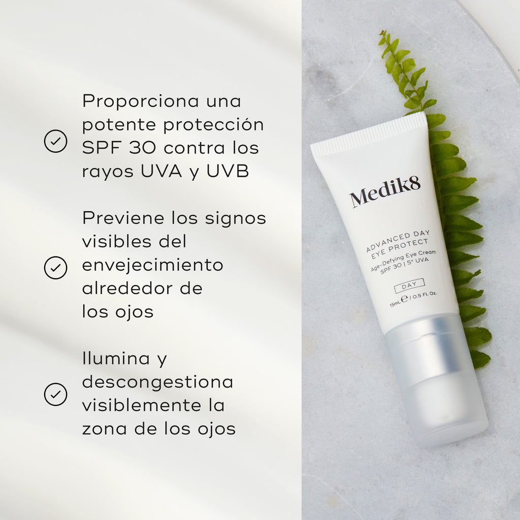 El tubo de Advanced Day Eye Protect yace sobre una superficie de mármol junto a una hoja verde de helecho. El texto destaca su protección SPF 30, la prevención de los signos visibles del envejecimiento y su capacidad para iluminar y desinflamar el contorno de ojos.