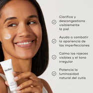 Una lista de beneficios aparece junto a una modelo sosteniendo el tubo de Clarity Peptides. El texto afirma que ayuda a clarificar visiblemente la tez, combatir las imperfecciones, calmar el enrojecimiento y aumentar la luminosidad.