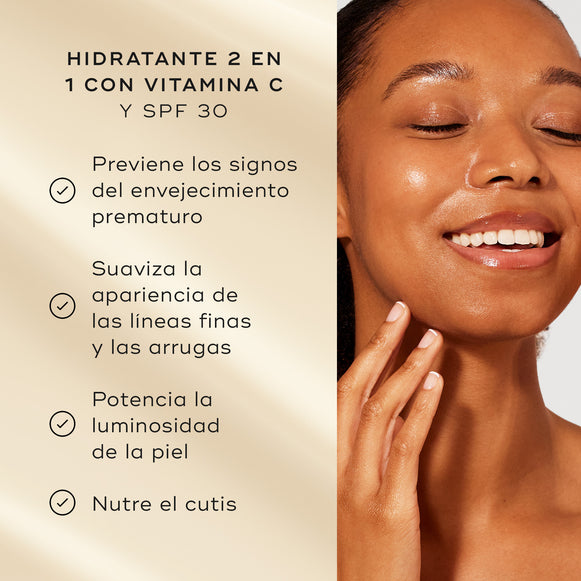 Una modelo con piel luminosa sonríe junto a una lista de beneficios del producto sobre un fondo dorado suave. El texto destaca la crema hidratante 2 en 1 con vitamina C y SPF 30:

Previene los signos del envejecimiento prematuro
Potencia la luminosidad de la piel
Hidrata el cutis
El 100 % está de acuerdo en que su piel se siente protegida durante todo el día-hover-22