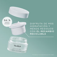Vista explotada del envase de Medik8 Total Moisture Daily Facial Cream sobre un fondo verde azulado. Muestra el tarro de vidrio esmerilado vacío en la parte inferior, una cápsula de recarga reciclable blanca con crema blanca flotando sobre él y la tapa blanca suspendida en la parte superior. El texto destaca: «DISFRUTA DE MÁS HIDRATACIÓN Y MENOS RESIDUOS CON LA CÁPSULA DE RECARGA RECICLABLE», y un distintivo circular indica «94 % MENOS EMBALAJE».