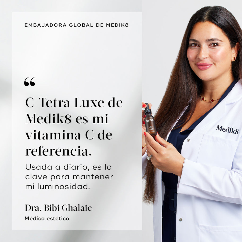 Dr. Bibi Ghalaie sonríe mientras lleva una bata de laboratorio blanca de Medik8 y sostiene una botella marrón de C-Tetra Luxe. A su lado aparece una cita que dice: «C-Tetra Luxe de Medik8 es mi vitamina C de referencia. Utilizada a diario, es la clave para mantener mi luminosidad».
