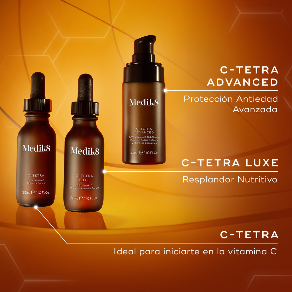 Gama de sérums con vitamina C de Medik8, que incluye C-Tetra (vitamina C introductoria), C-Tetra Luxe (luminosidad nutritiva) y C-Tetra Advanced (fórmula de defensa antiedad), mostrados sobre un fondo de tonos cálidos.