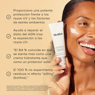 Un modelo sonriente sostiene el tubo de Medik8 Advanced Day Ultimate Protect con una muestra de crema blanca en la mejilla sobre un fondo beige cálido. El texto destaca cuatro beneficios clave: protección avanzada contra los rayos UV y los factores de estrés ambiental, reparación del daño en el ADN tras la exposición a los rayos UV, el 94 % está de acuerdo en que se siente como una crema hidratante y el 100 % no experimentó formación de grumos ni efecto “pilling”.
